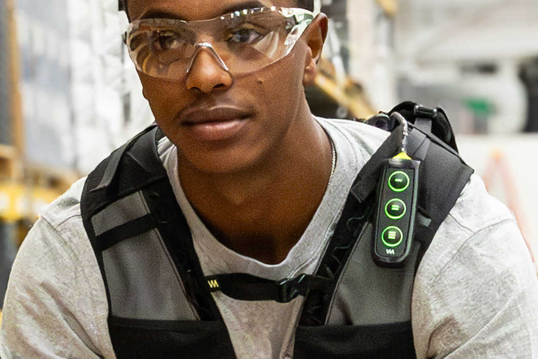 Worker adjusting the SafeLift™ exosuit chest-mounted controller.